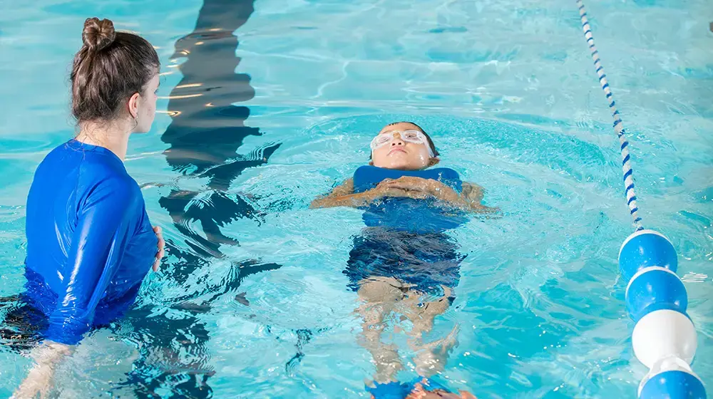 Maryam Aquatics & Bodyworks instructor teaching child to swim